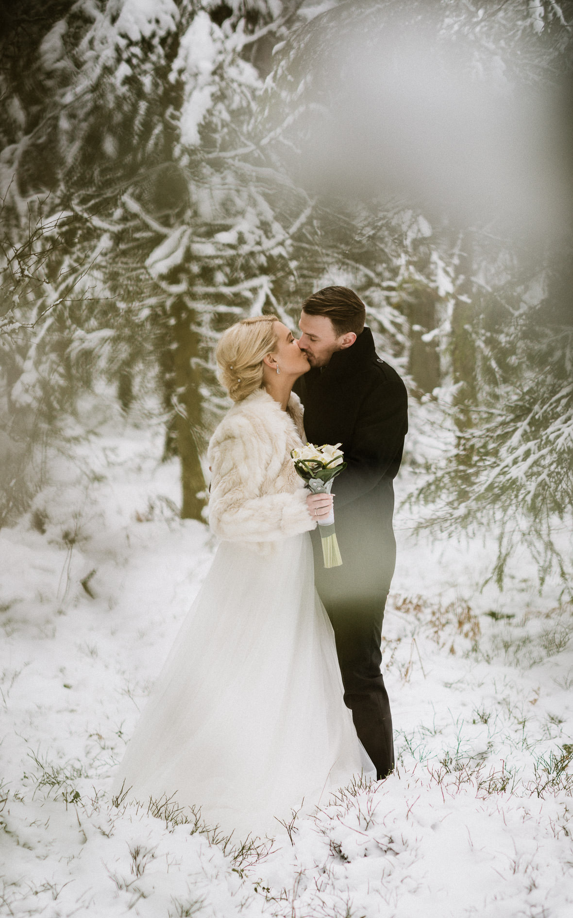 Kyssande brudpar i snön - vinterbröllopsfoto av bröllopsfotograf Johan Lindqvist